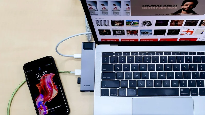 USB 케이블로 스마트폰과 노트북을 연결해 둔 책상 풍경