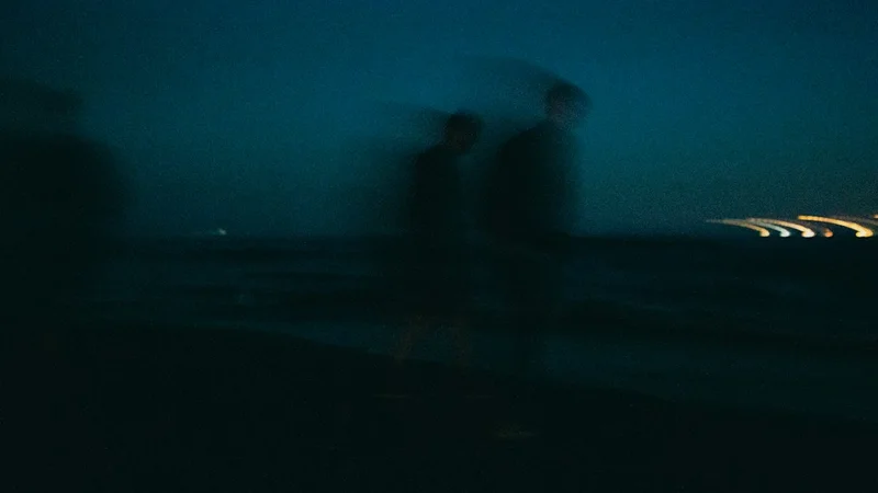 해변 모래사장에 돗자리를 펴고 앉아 불꽃을 기다리는 관람객들